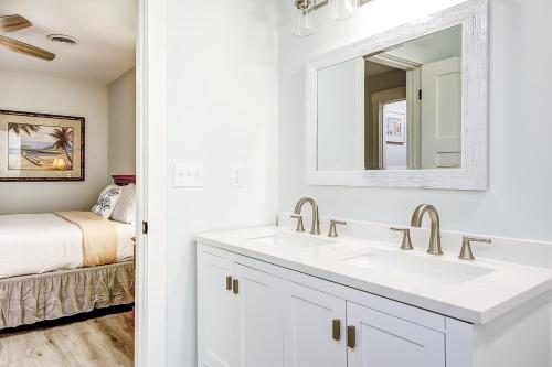 a white bathroom with a sink and a mirror at Pleasant Dreams in Charleston