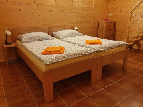 a bed in a room with two orange towels on it at Sport-hotel Šibeniční vrch in Mnichovice