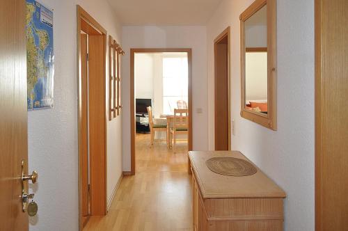 Zimmer mit einem Flur mit einem Tisch und einer Tür in der Unterkunft Nemo Home in Ummanz
