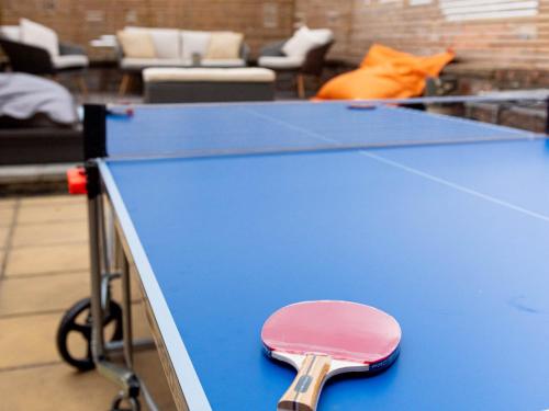 una mesa de ping pong con una paleta de ping pong en The Penthouse, en Cromer