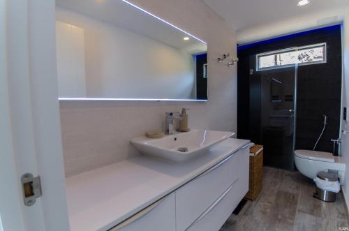 Un baño blanco con lavabo e inodoro. en Vv - Ocean view Dream Apartment, en San Agustín