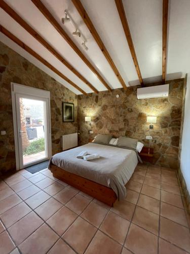 una camera con un letto in una parete in pietra di B&B Casa El Viaje a Cómpeta