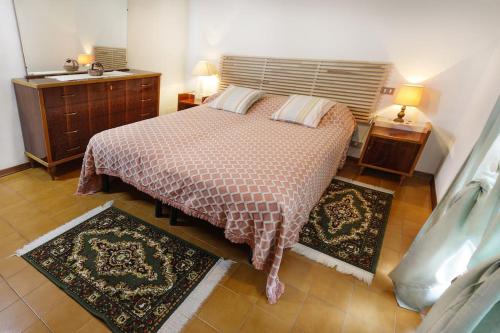 a bedroom with a bed and two rugs on the floor at La casa di Mario e Olga in San Martino