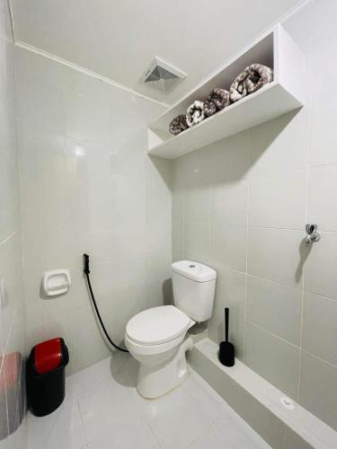 a white bathroom with a toilet and a shelf at Lovely 2 bedroom condo unit in Iloilo City