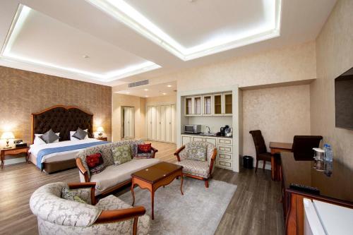 a hotel room with a bed and a living room at Sapphire Inn Hotel in Baku