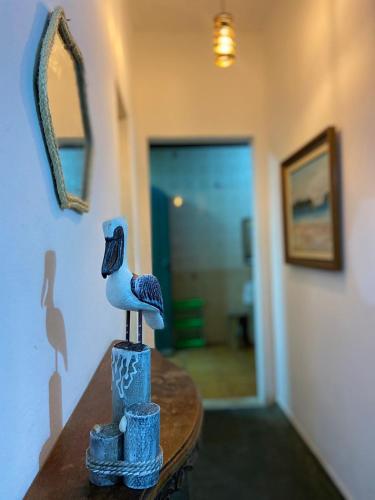 una figurita de un pájaro sentada sobre una mesa en Casa em Arraial do Cabo, en Arraial do Cabo