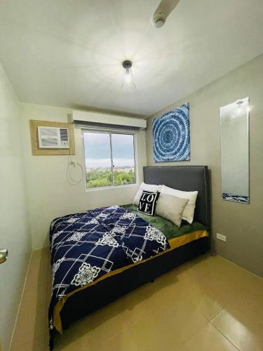 a small bedroom with a bed and a window at Lovely 2 bedroom condo unit in Iloilo City