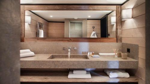 a bathroom with a sink and a large mirror at Attività per la famiglia e percorsi per escursioni a piedi o in mountain bike in La Thuile