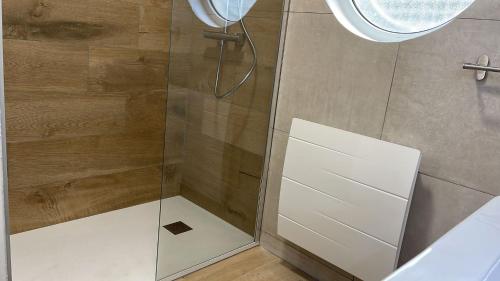 a shower with a glass door in a bathroom at Le Gîte au bord du Lac in Gérardmer