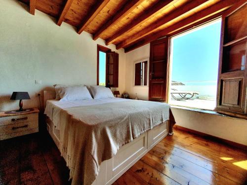 1 dormitorio con cama y ventana grande en Studio 1, en Patmos