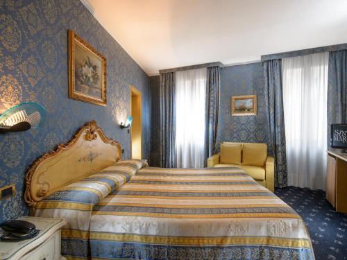 a hotel room with a bed and a chair at Hotel Santa Marina in Venice