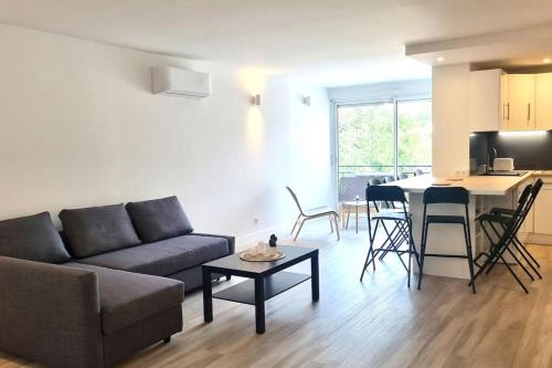 un salon avec un canapé et une table dans l'établissement Résidence Anthérieu - Appartements neufs tout confort, à Frontignan