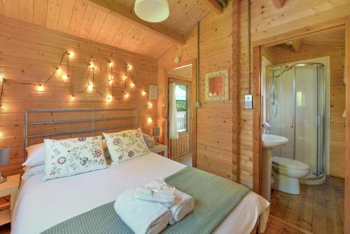 a bedroom with a bed in a wooden cabin at The Cabin with Hot Tub in Maidstone