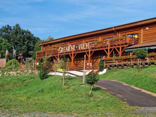 a wooden building with a sign on the side of it at Sport-hotel Šibeniční vrch in Mnichovice