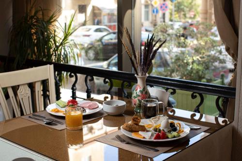 een tafel met twee borden eten op een balkon bij Sapphire Inn Hotel in Baku
