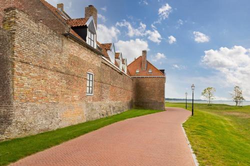 a brick wall with a path next to it at Schitterende Water Loft hartje centrum Harderwijk in Harderwijk