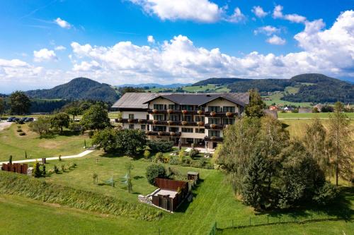 a view of a resort with mountains in the background at Der Trattner - Hotel Trattnerhof & Hotel Schöcklblick in Semriach