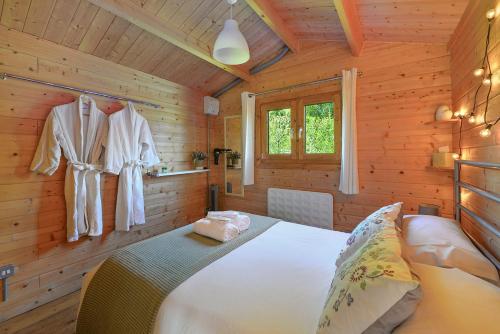 a bedroom with a bed in a wooden cabin at The Cabin with Hot Tub in Maidstone