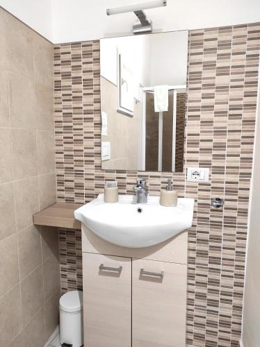 a bathroom with a white sink and a mirror at Dove nasce il Sole B&B in Nicolosi