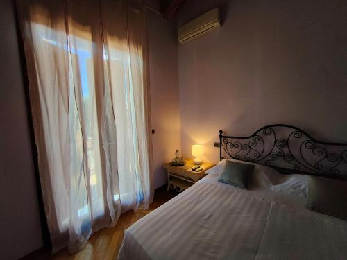 a bedroom with a bed and a large window at B&B Villa Letizia in San Vito Rimini
