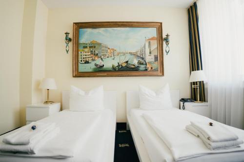 2 Betten in einem Zimmer mit Wandgemälde in der Unterkunft Altstadt Hotel St. Georg in Düsseldorf