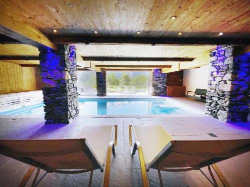 - une piscine dans un bâtiment avec un mur en pierre dans l'établissement Le Flocon, à Champagny-en-Vanoise
