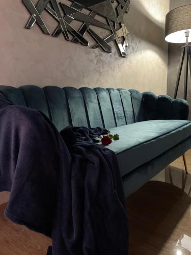 a blue couch with a blanket on top of it at Apartman Stefan Lux in Vrdnik