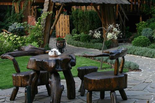 a wooden table and chairs with a tea kettle on it at Hotel Zameczek in Książ Wielki