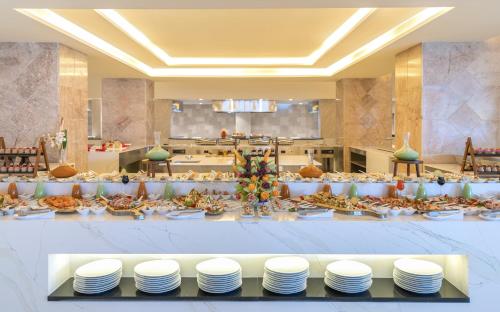 a buffet line with plates of food in a restaurant at Royal Azur Thalassa in Hammamet