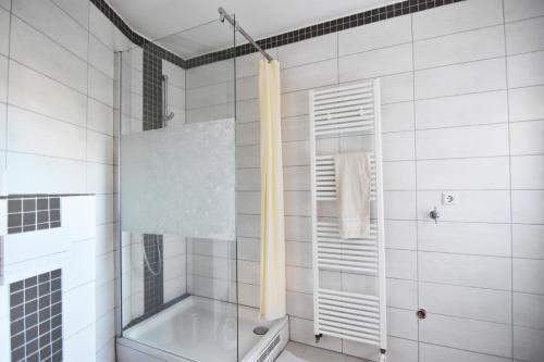 a bathroom with a tub and a glass shower at Work and Stay Troisdorf in Troisdorf