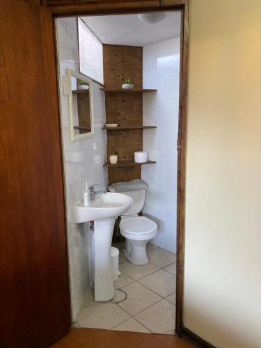 a bathroom with a toilet and a sink at Hostel El Bajo in Iquique
