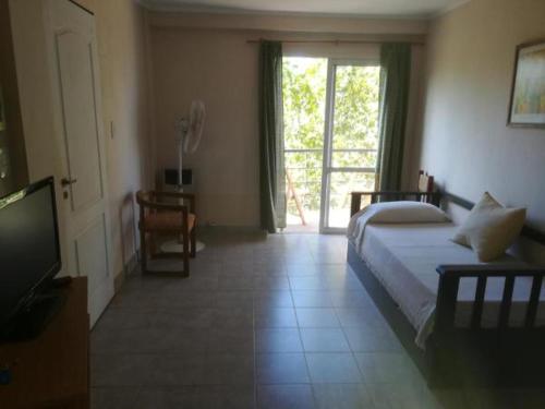 Un dormitorio con una cama y una puerta corrediza de vidrio. en Atalaya, en Colón