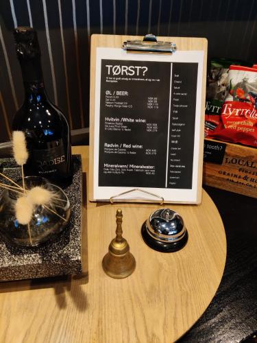 a sign on a table with a bottle of wine at First Hotel Millennium in Oslo