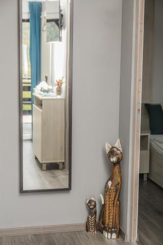 a mirror on a wall with a cat statue in front of it at Aranyos Hillside in Nagymaros