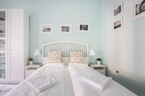 - une chambre blanche avec un grand lit et 2 tables dans l'établissement Stella Apartment, à Budapest