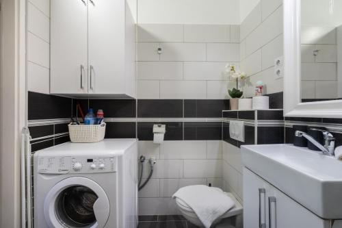La salle de bains est pourvue d'un lave-linge et d'un lavabo. dans l'établissement Stella Apartment, à Budapest