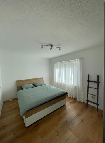 a white bedroom with a bed and a window at Appartamento Wyss in Bivio