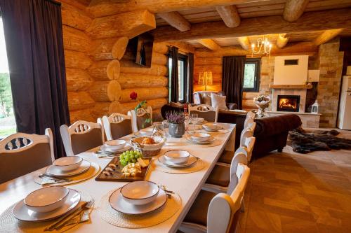 a dining room with a long table and chairs at Harghita Log Houses in Izvoare