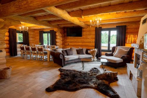 a living room with a couch and a table at Harghita Log Houses in Izvoare