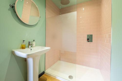 een badkamer met een wastafel en een douche bij The Nissen Hut at Green Valley Farm in Laxfield