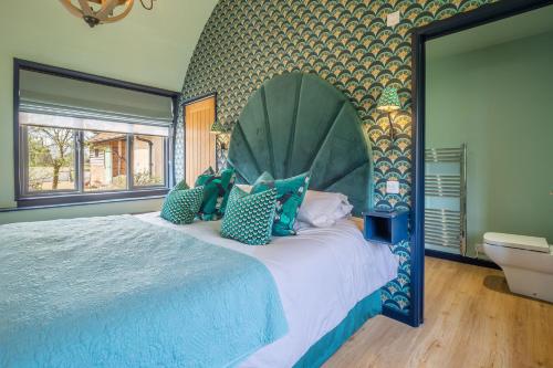 1 dormitorio con 1 cama grande y cabecero grande en The Nissen Hut at Green Valley Farm, en Laxfield