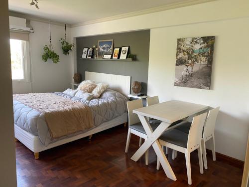 1 dormitorio con 1 cama, mesa y sillas en G3 Inn apartments en Mendoza