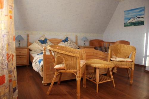 a bedroom with a bed with wicker chairs and a table at Ferienhaus Brigitte in Dornum