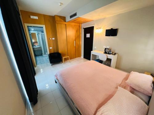 a bedroom with a bed and a desk and a bathroom at hotel garni Santa Caterina in Orta San Giulio