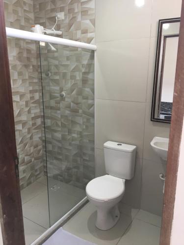 a bathroom with a toilet and a glass shower at Casa de Praia Tamandare in Tamandaré