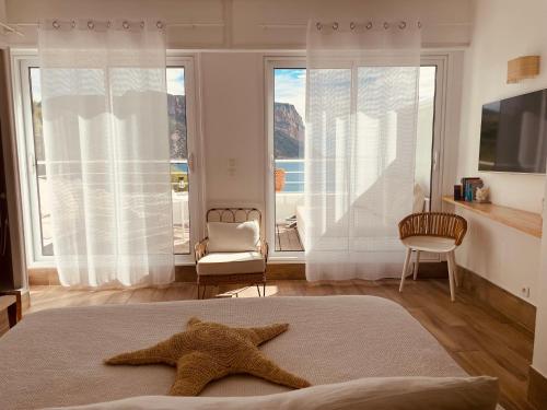 ein Seestern auf einem Bett in einem Zimmer mit Fenstern in der Unterkunft Hotel de La Plage - Mahogany in Cassis