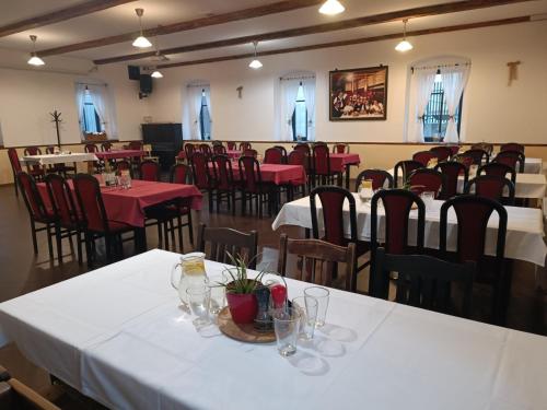 Penzion U Švarců في Zduchovice: غرفة طعام مع طاولات وكراسي مع قماش الطاولة البيضاء