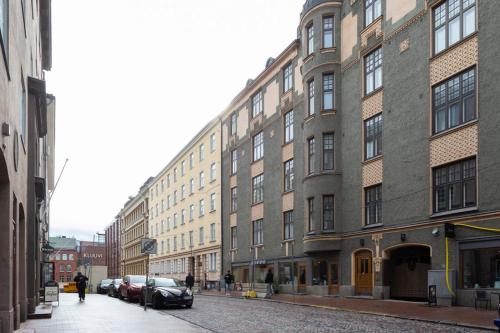 a street with cars parked in front of a building at 2ndhomes Cozy Studio in the City Center in Helsinki