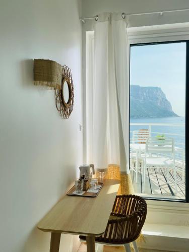 a table and two chairs in a room with a window at Hotel de La Plage - Mahogany in Cassis