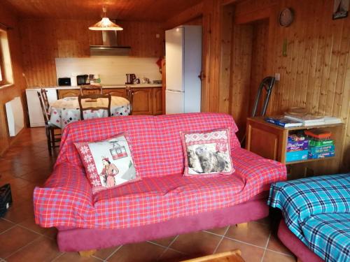 een woonkamer met een rode bank en een keuken bij Bel appartement au rez de chaussée d'un chalet in Jarrier